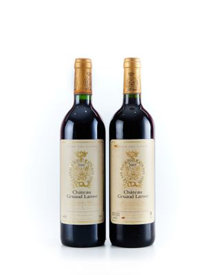 deux bouteilles de vin posées l'une à côté de l'autre sur une surface blanche
