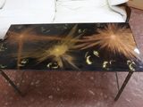 une table basse ornée d'un motif noir et doré