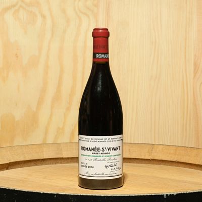 a bottle of wine sitting on top of a barrel