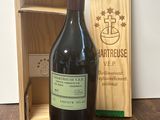 une bouteille de vin posée sur une table à côté d'une caisse en bois