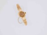 a close up of a gold watch on a white surface