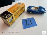 une petite voiture bleue posée à côté d'un paquet de cigarettes sur une table