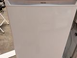 a white refrigerator sitting on the floor next to a dryer