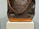 un sac à main marron et beige posé sur une boîte blanche