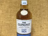une bouteille de whisky The Glenlivett posée sur une table