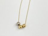 a gold and silver beaded necklace on a white background