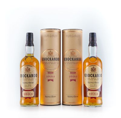 trois bouteilles de whisky sont posées les unes à côté des autres sur une surface blanche
