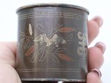 a person holding a tin with a design on it