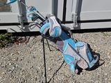 a bag of golf equipment on the ground next to a container