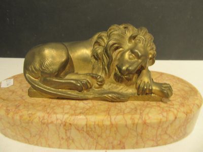 a statue of a lion laying down on a marble base