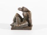 sculpture en bronze représentant une femme assise sur un rocher, les jambes croisées