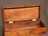 an old wooden box with a drawer on top of it