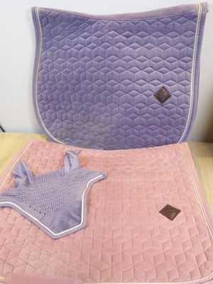 purple and pink quilted saddle pad and blanket on a wooden table