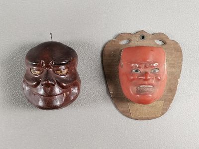 deux masques accrochés au mur l'un à côté de l'autre