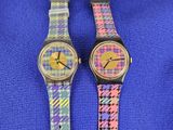 deux montres colorées posées l'une à côté de l'autre sur une couverture bleue