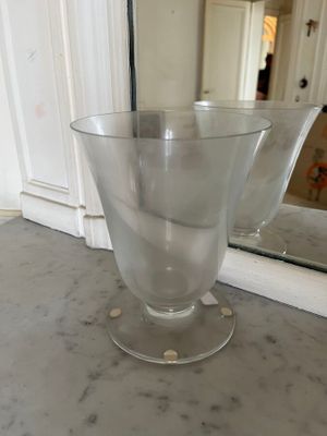 a glass vase sitting on a counter in front of a mirror