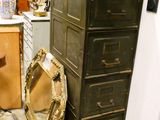 une grande commode surmontée d'un miroir, dans une pièce