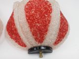 two red and white christmas ornaments on a white surface