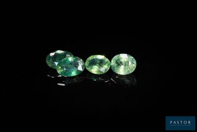 a pair of green tourmaline gems on a black background