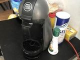 a coffee maker sitting on a counter next to a can of soda
