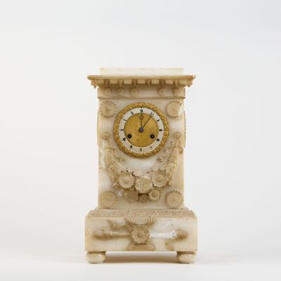 a white clock with a gold face on a stand