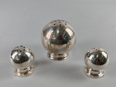 three silver salt and pepper shakers on a white surface