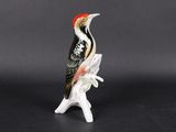 un gros plan d'une figurine représentant un oiseau perché sur une branche