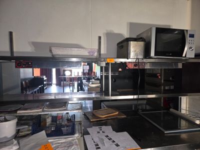 une cuisine équipée d'une cuisinière, d'un micro-ondes et d'autres ustensiles posés sur le plan de travail