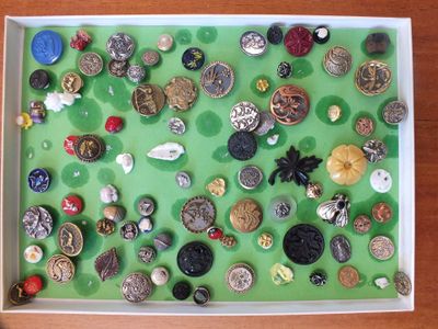 une boîte remplie de nombreux boutons posée sur une table