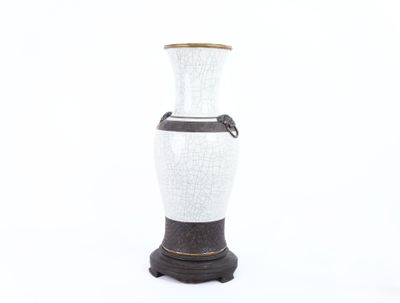 un vase blanc et noir posé sur un socle noir