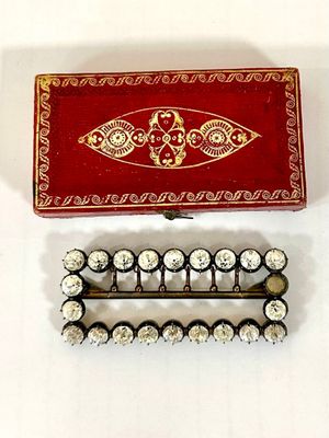 two pieces of jewelry that are sitting on a table
