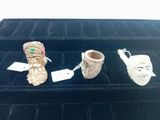three small ceramic figurines are sitting on a velvet tray