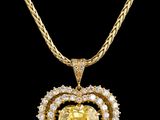 un pendentif en forme de cœur, orné d'un saphir jaune et de diamants, monté sur une chaîne en or