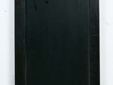 a black door with a metal handle on the wall