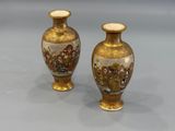 two vases are sitting on a table with a gray background