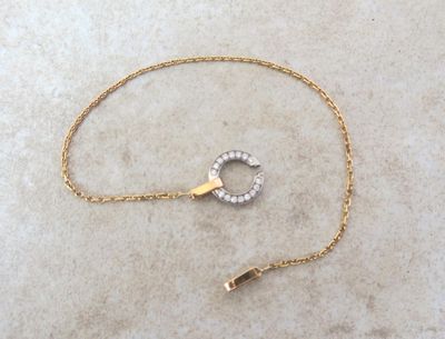 collier plaqué or composé d'une chaîne, d'un pendentif en forme de cercle et d'un fermoir en forme de diamant