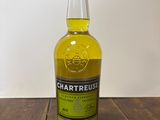 une bouteille de whisky à la Chartreuse posée sur une table en bois