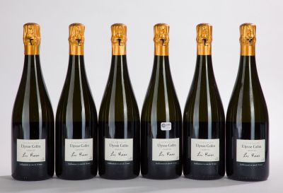 six bouteilles de vin sont alignées sur une surface blanche