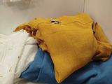 a pile of clothes sitting on top of a bed
