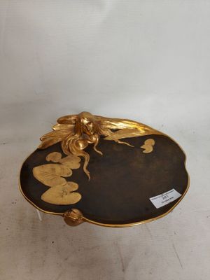 une image représentant une assiette dorée et noire ornée d'un dragon