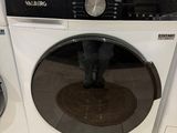deux lave-linge et un sèche-linge exposés dans un magasin
