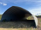 a large metal structure sitting in the middle of a field