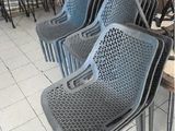 Plusieurs chaises en plastique sont alignées en rang dans un restaurant