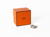 une boîte orange contenant une bague, posée sur une surface blanche