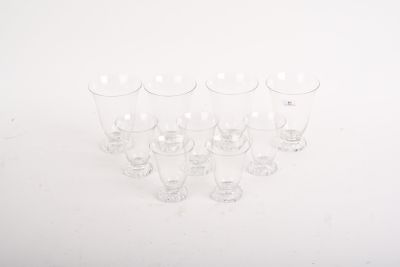 plusieurs verres à vin vides sont alignés sur une surface blanche