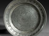 une vieille assiette en argent ornée d'un motif décoratif