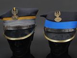 pair of military hats on a mannequin head on a black background