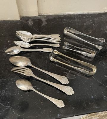 beaucoup de cuillères en argent et de cuillères à soupe sur une table