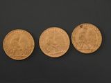 three different types of gold coins on a black surface