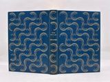 un vieux livre à la couverture bleue ornée de volutes argentées